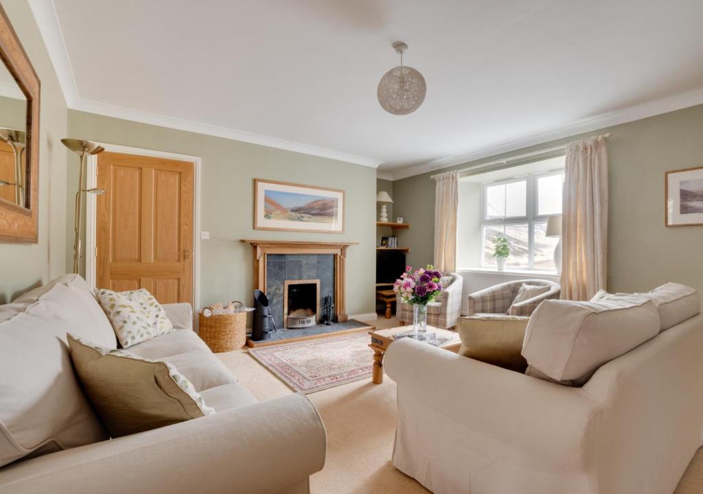 sala de estar con 2 sofás blancos y chimenea en Dunsdale House, en Kirknewton