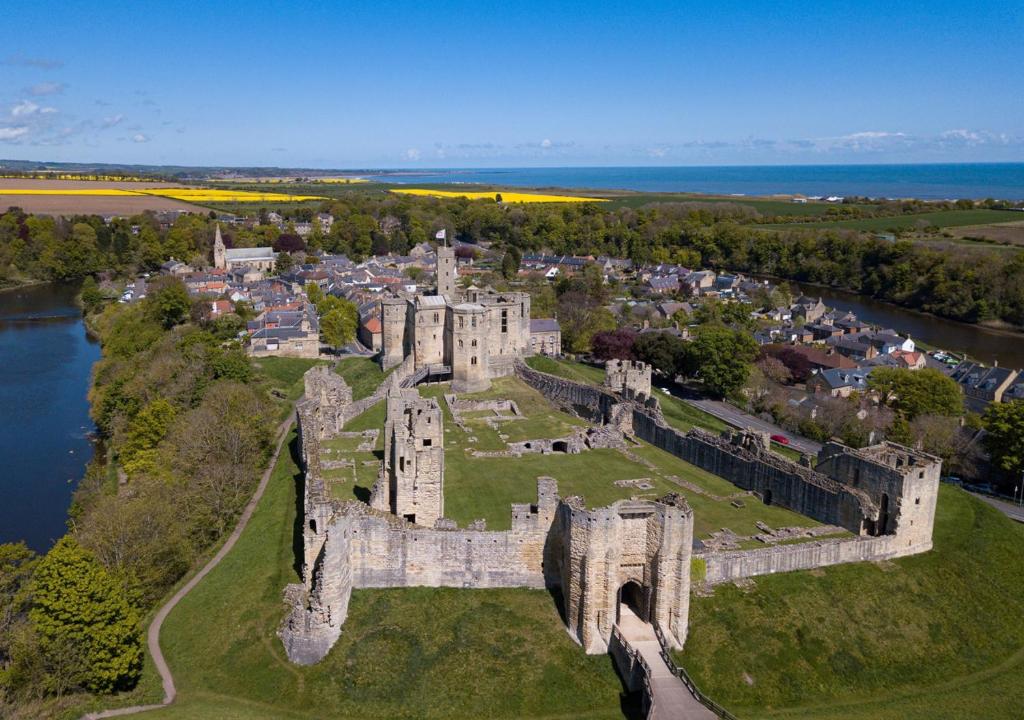 an aerial view of a castle and a city at Waters Edge - Warkworth in Warkworth