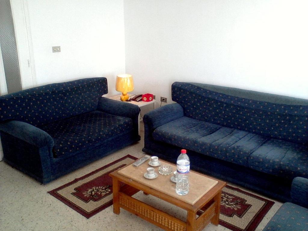 a living room with two blue couches and a coffee table at Excellent Appartment Sousse in Sousse
