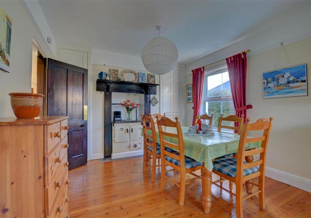 a kitchen and dining room with a table and chairs at Trearth in St Merryn