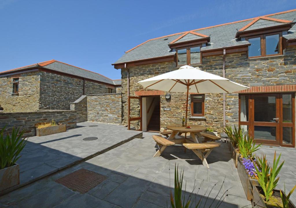 a patio with a table and an umbrella at Bowgie in Saint Merryn