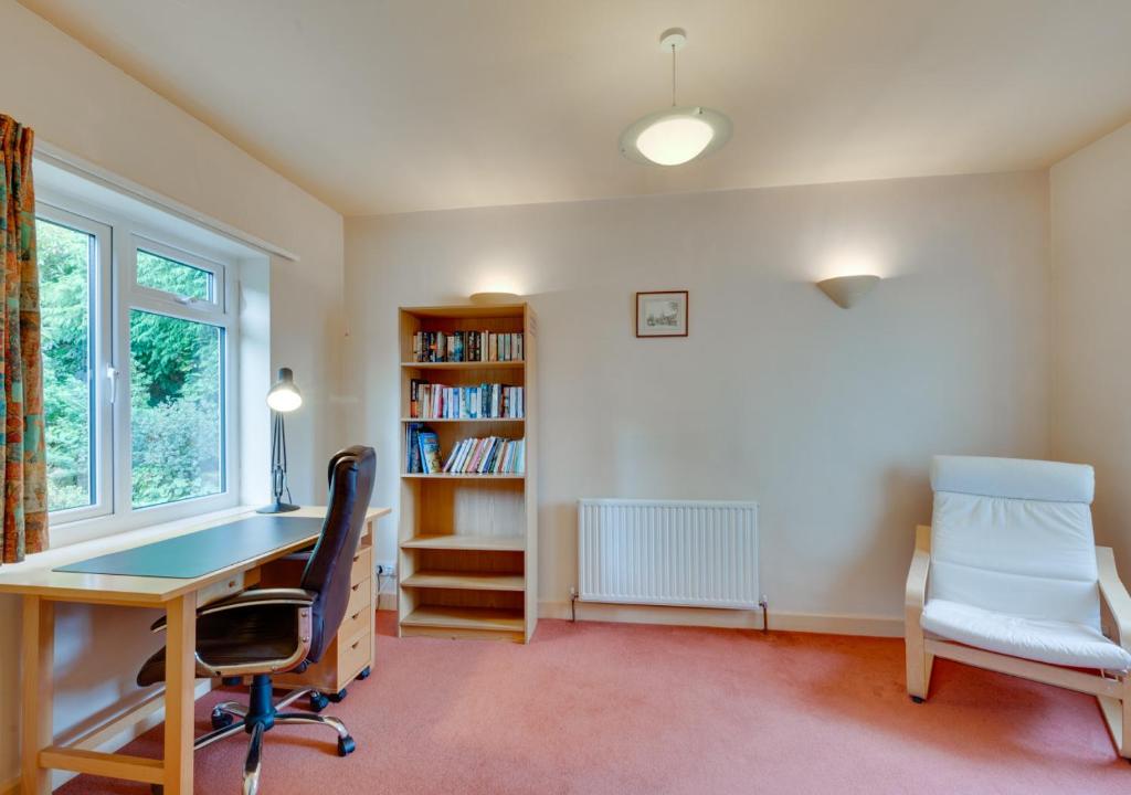 een thuiskantoor met een bureau en een boekenplank bij Middleton View in Ilkley