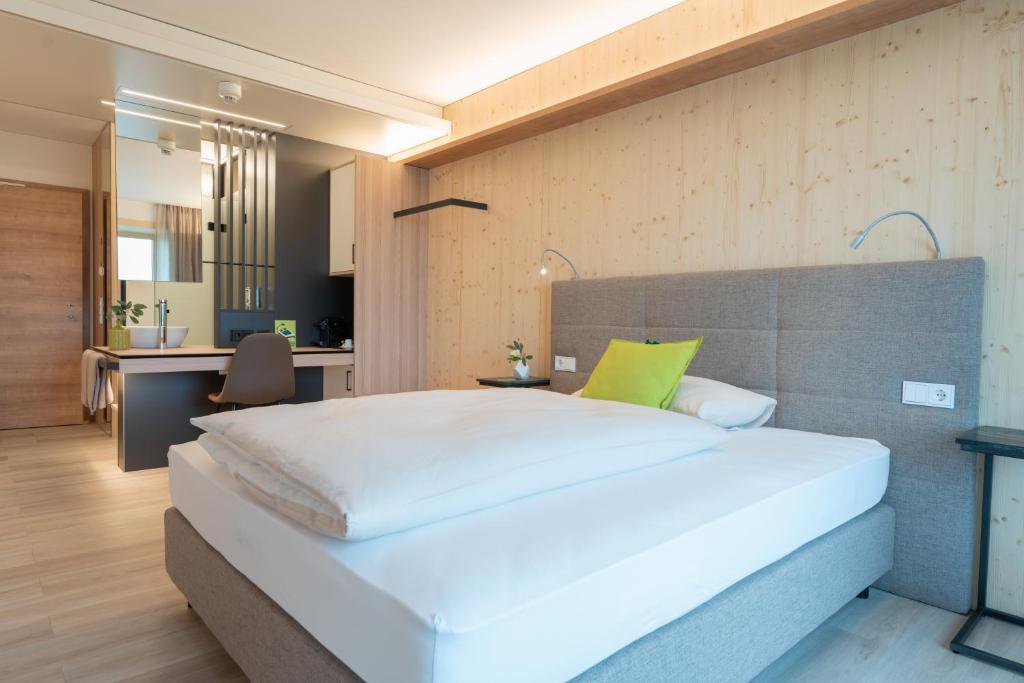 een slaapkamer met een groot wit bed en een bureau bij eee Hotel Eberstalzell 