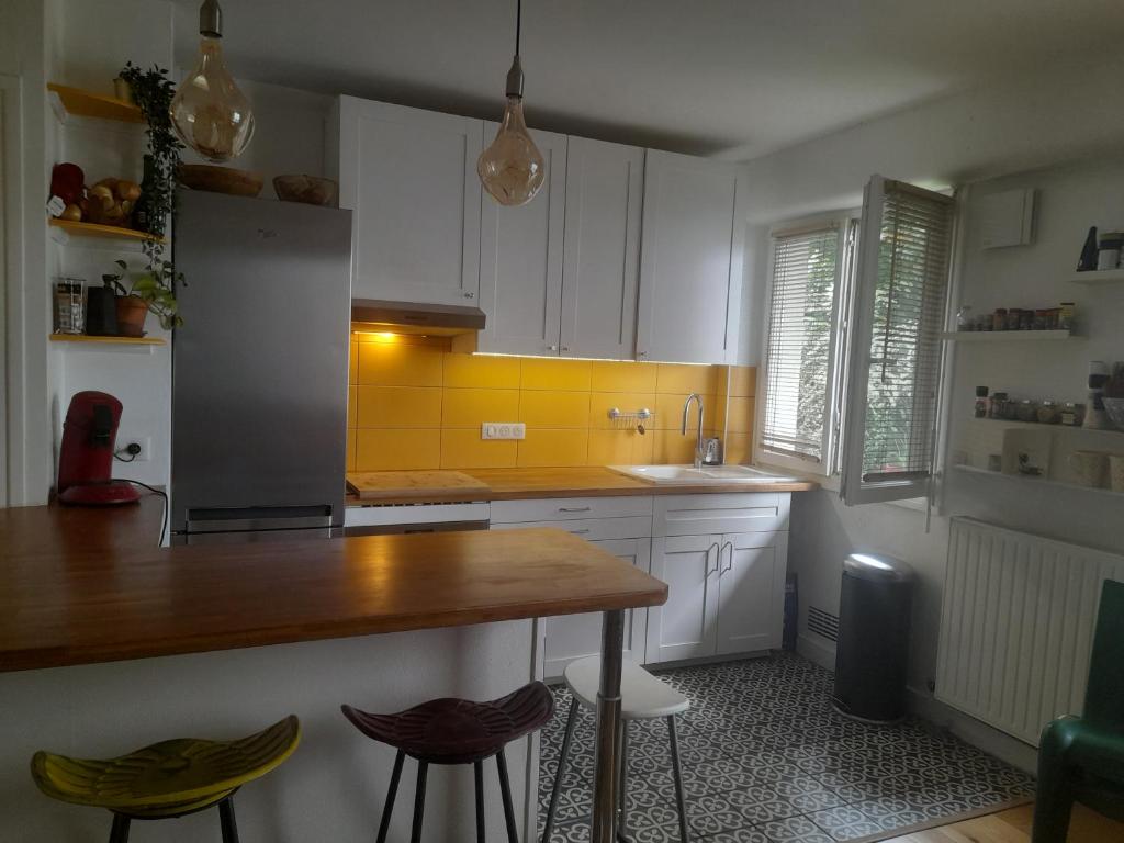 une cuisine avec des armoires blanches et un comptoir en bois dans l'établissement Nid douillet cœur de ville, à Tours