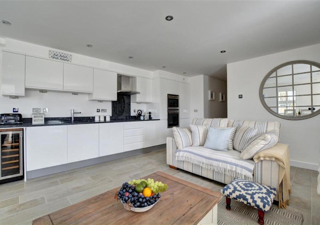 a living room with a couch and a kitchen at 1 Seaspell Apartment in Saint Merryn