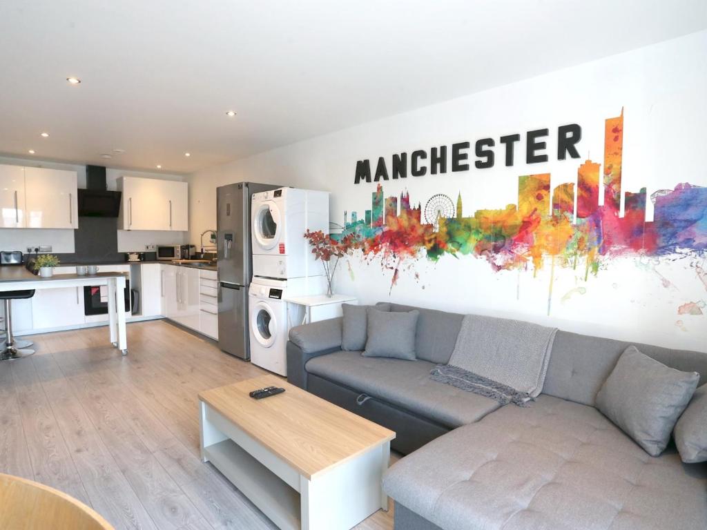 a living room with a couch and a kitchen at Pass the Keys Free Parking Central Apartment in Manchester