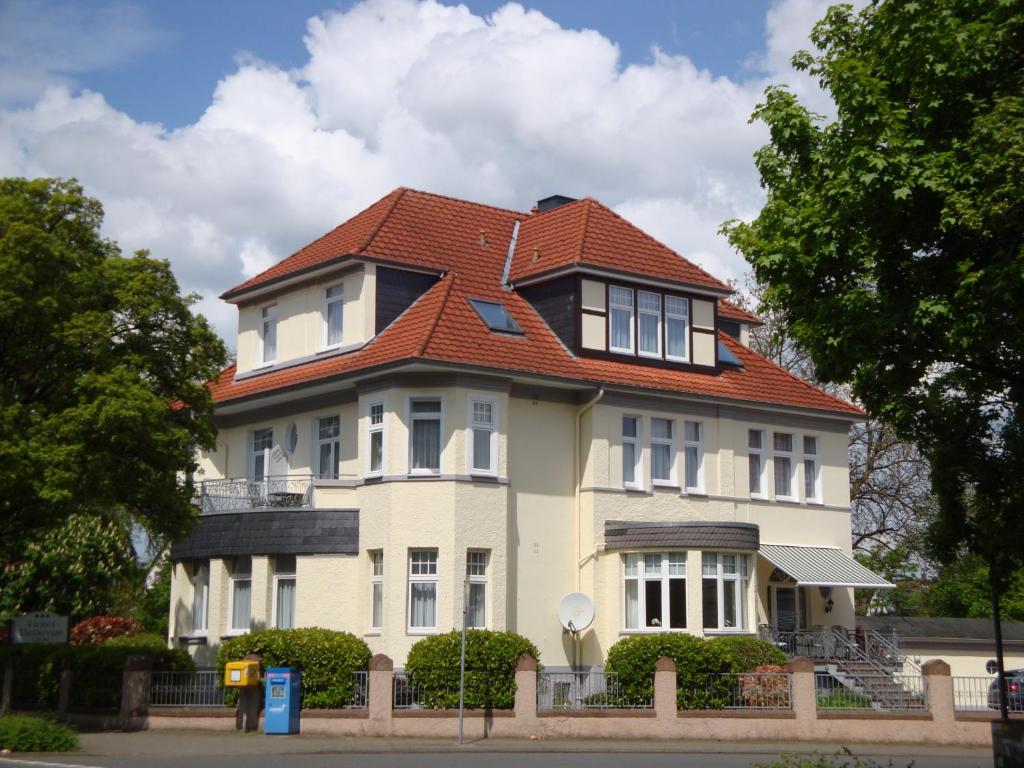 una gran casa blanca con techo rojo en Hotel Bellevue, en Hameln