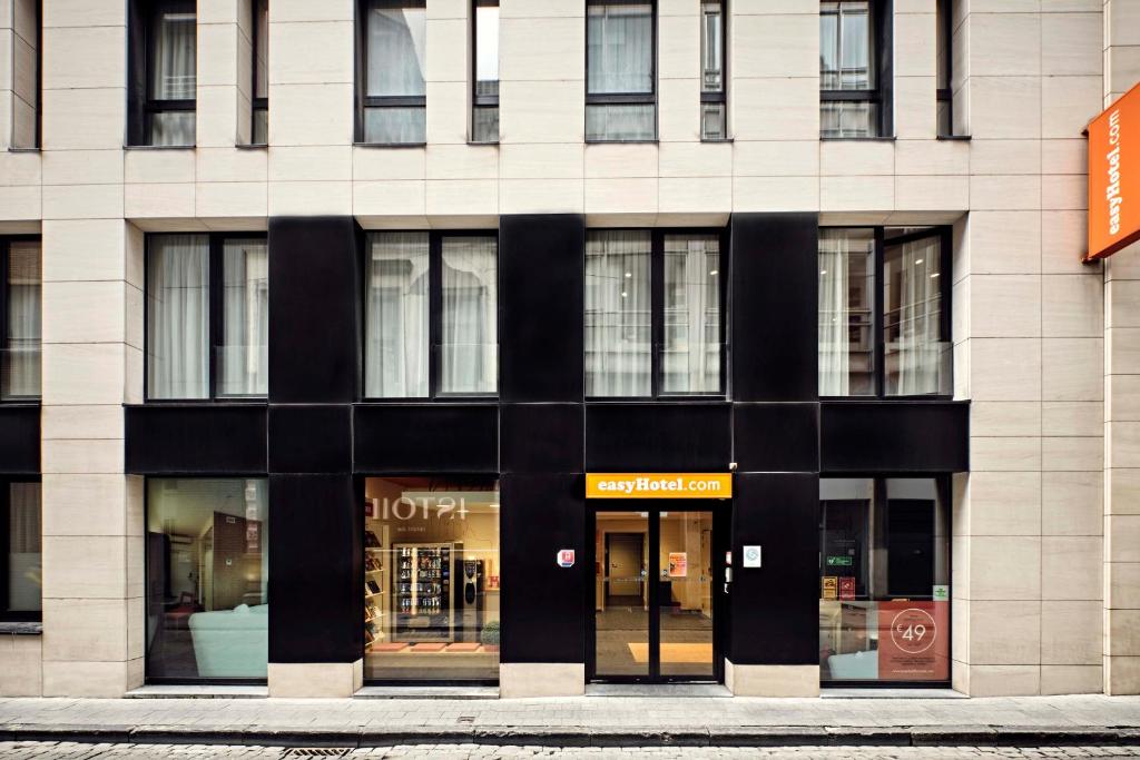 un grand bâtiment avec des fenêtres donnant sur une rue de la ville dans l'établissement easyHotel Brussels City Centre, à Bruxelles