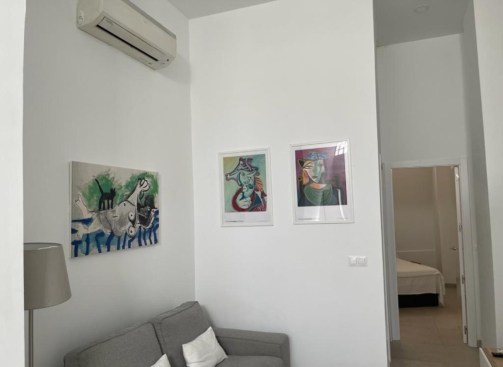 ein Wohnzimmer mit vier Bildern an der Wand in der Unterkunft MN Homes Fonseca B in Málaga