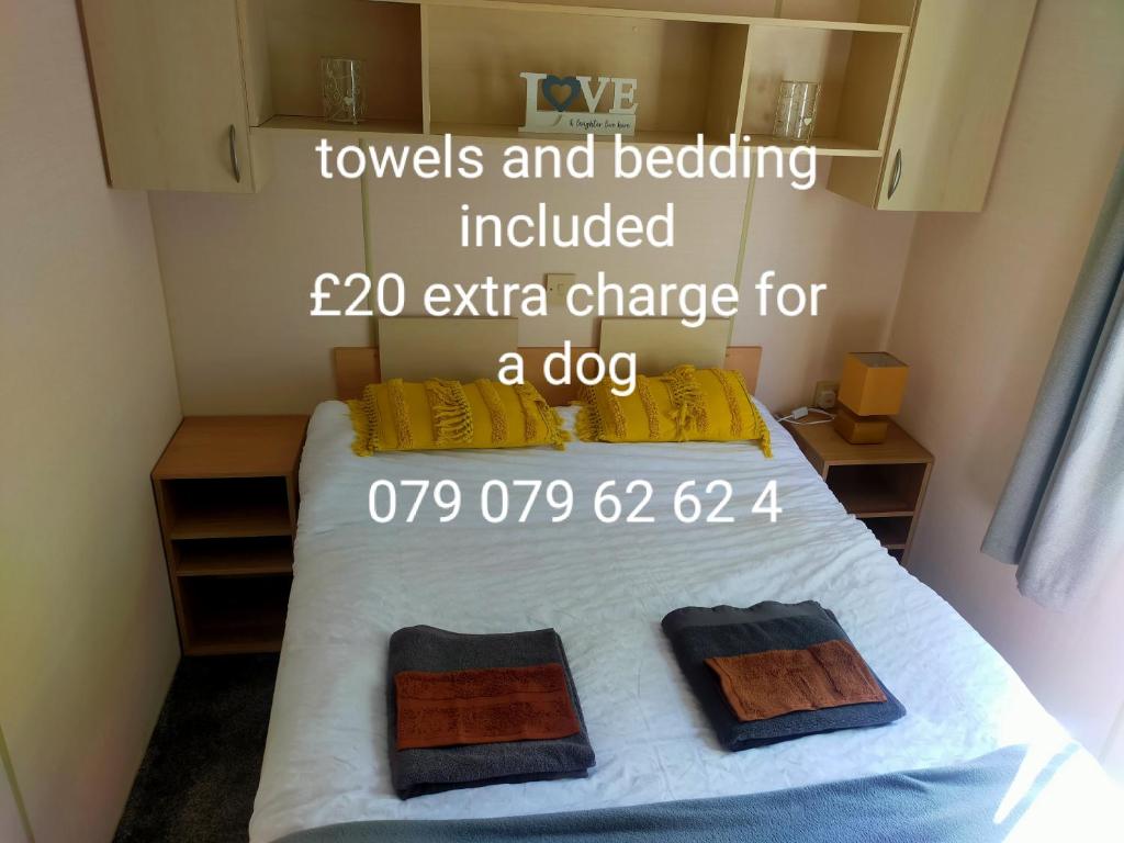 um quarto com uma cama com 2 toalhas e roupa de cama incluídos custo extra em Lily Jo caravan Skipsea Sands at Parkdean Resort em Skipsea