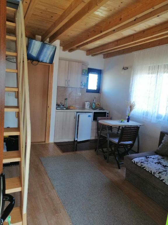 a living room with a table and a kitchen at Tarin zov in Kaludjerske Bare