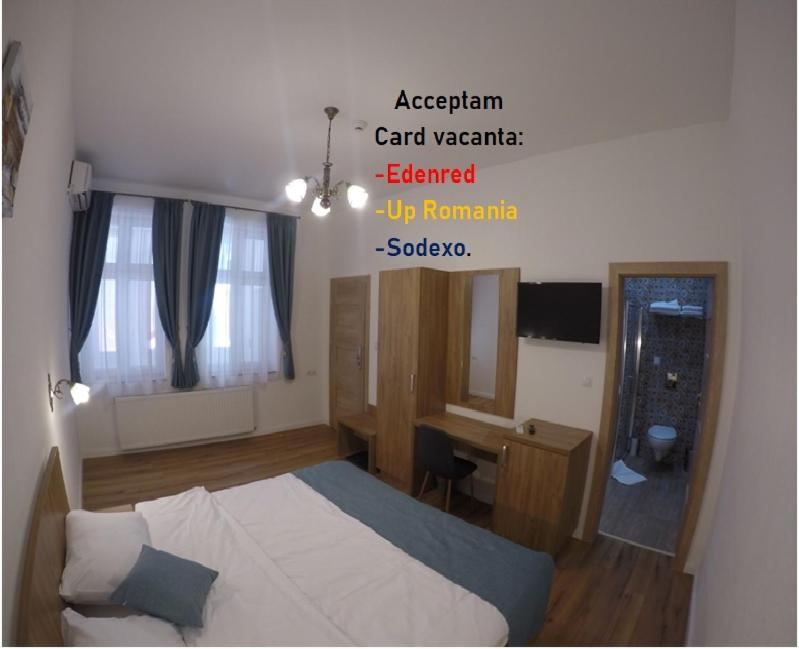 a hotel room with a bed and a desk and a room at Casa Bacila in Sibiu