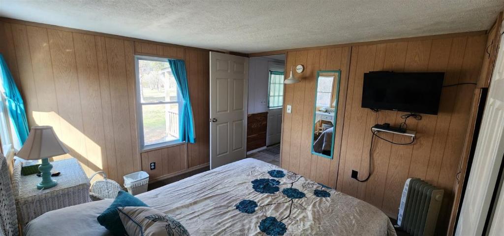 a bedroom with a bed and a flat screen tv at Millie`s Place in Luray