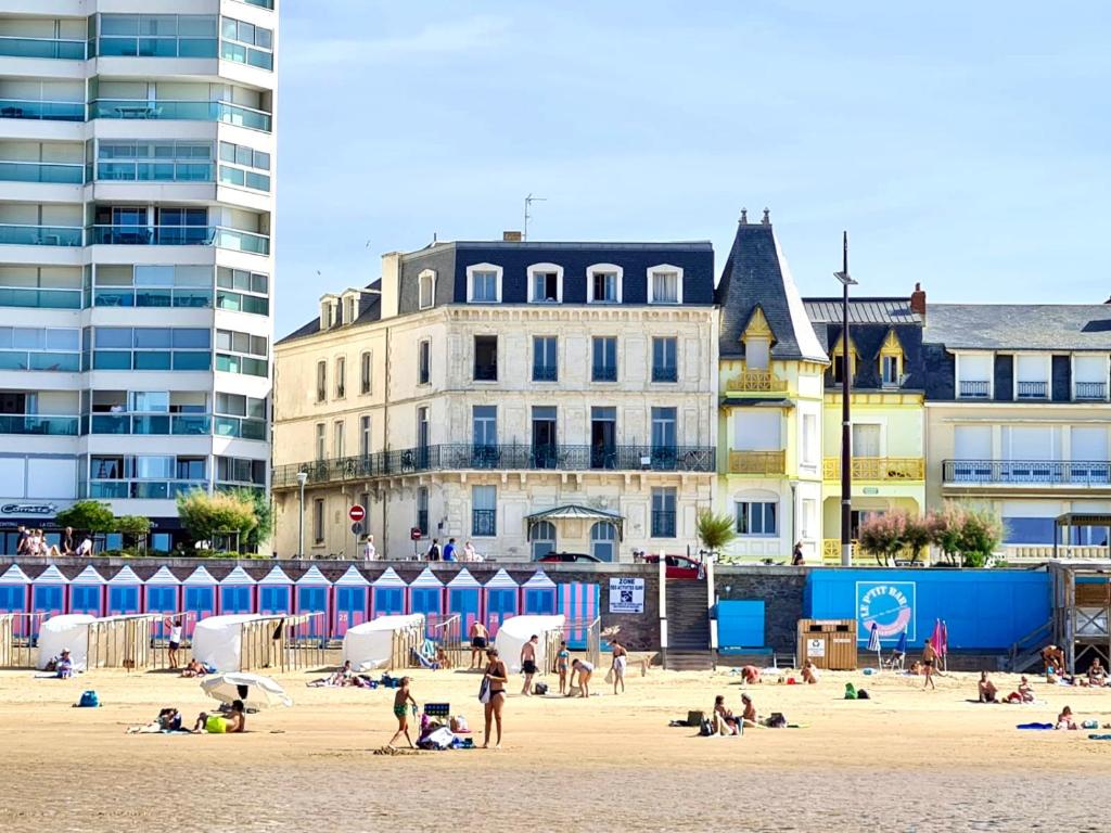 una playa con gente en la arena y edificios en Ma Location Sablaise - Appart' Grande Plage, en Les Sables-dʼOlonne