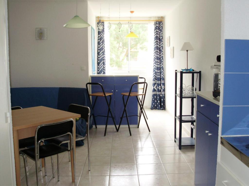 une cuisine et une salle à manger avec une table et des chaises dans l'établissement Appartement F1 Calvi à 150 mètres de la plage, à Calvi