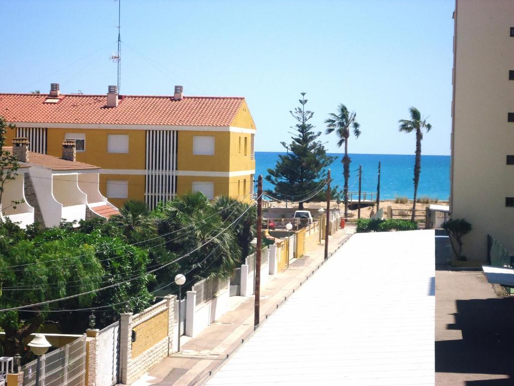 una pasarela frente a un edificio amarillo y el océano en El Penon, en Peñíscola