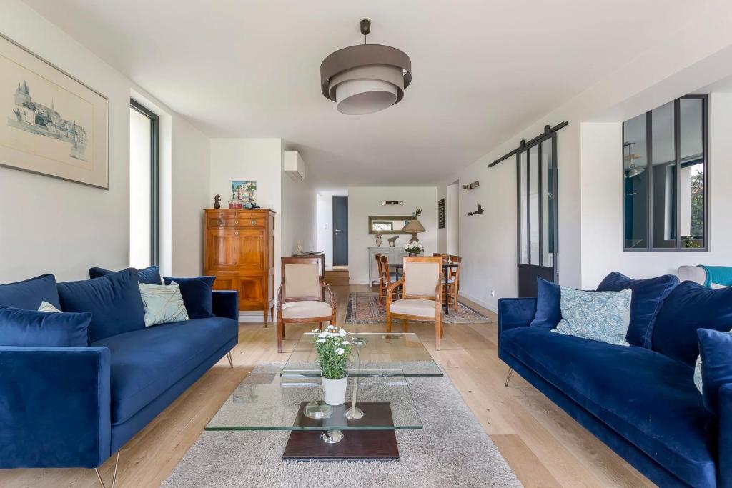 uma sala de estar com sofás azuis e uma mesa em Familial villa with pool - Tassin-la-Demi-Lune - Welkeys em Tassin-la-Demi-Lune