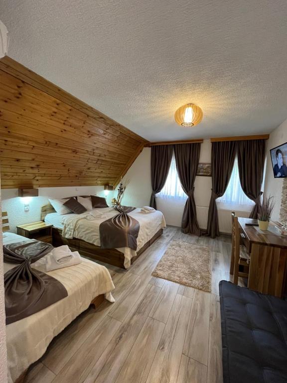 a bedroom with two beds and a table and a desk at Rustic Inn River 2 in Plitvička Jezera