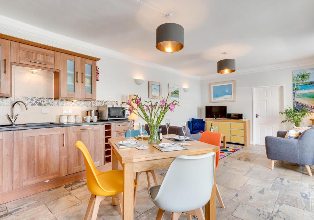 a kitchen and living room with a table and chairs at Pebbles Marazion in Marazion