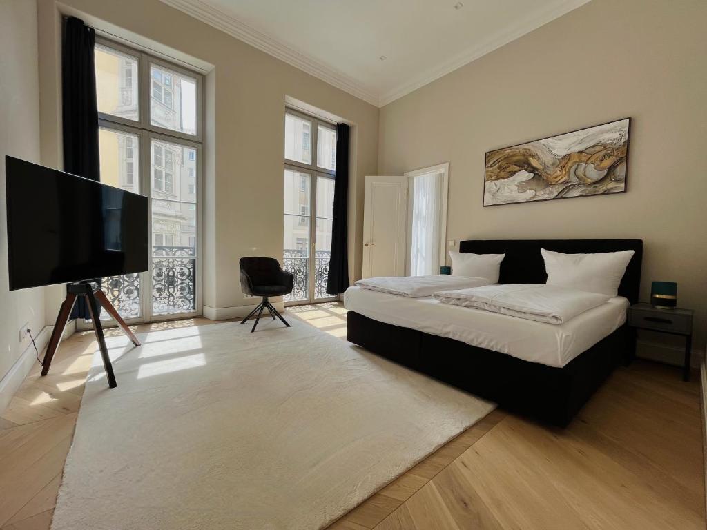 a bedroom with a bed and a flat screen tv at Luxury Home / 3-Raum-Suite an der Frauenkirche / 2 in Dresden