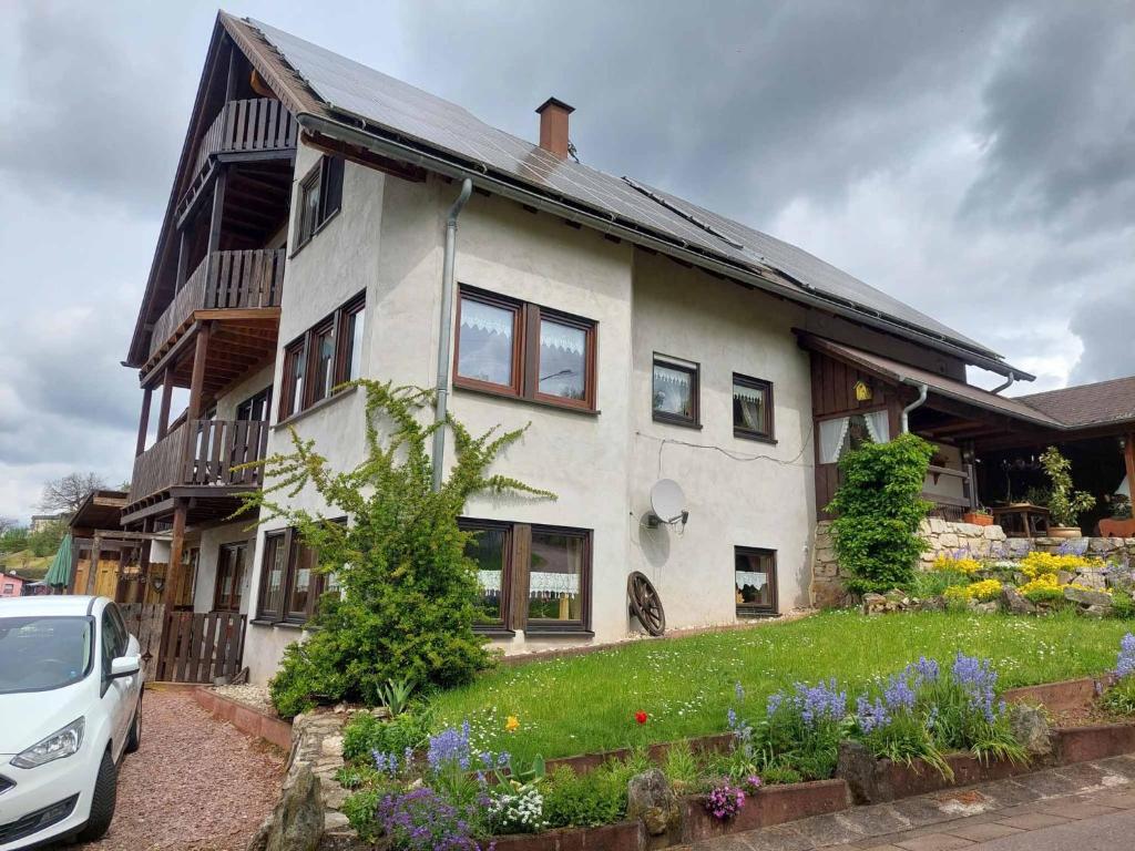 a house with a car parked in front of it at Ferienwohnung Eisbach Lamas in Wadern