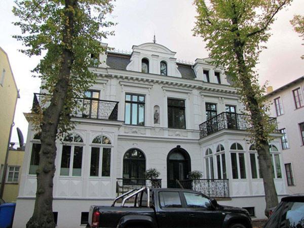 a black truck parked in front of a white building at Villa Parkblick in Rostock
