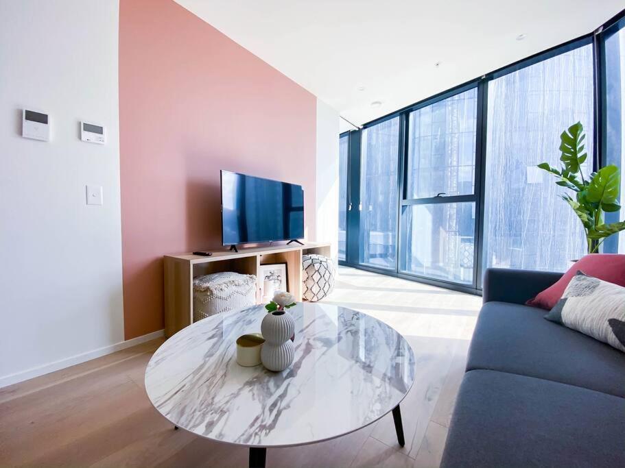 een woonkamer met een tafel en een bank bij Glamorous Southbank home#MSQ1410 in Melbourne