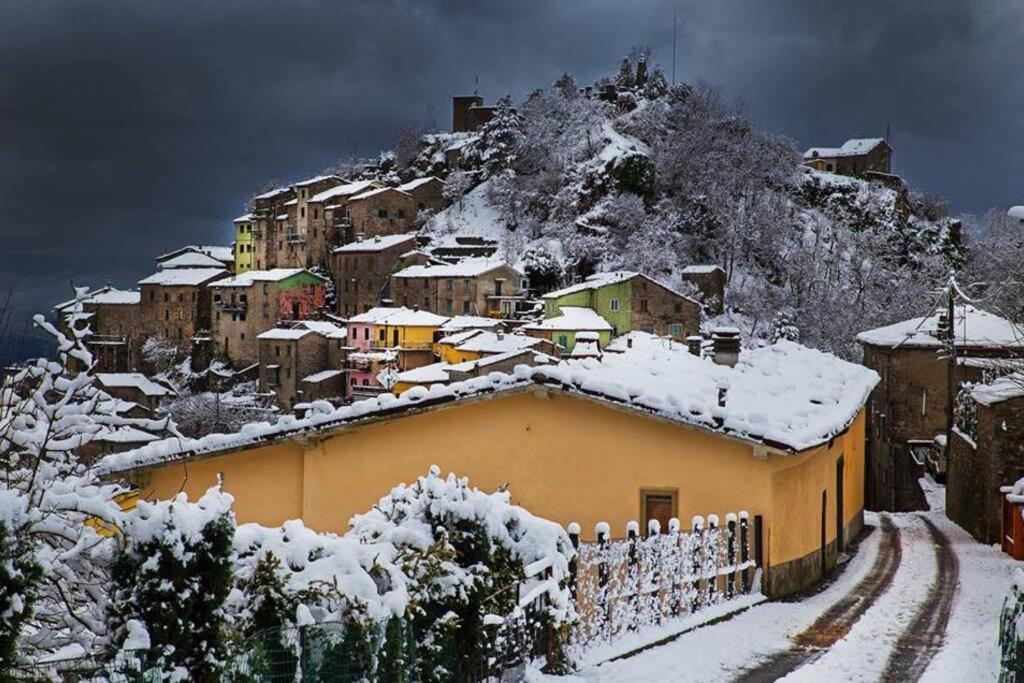 a village covered in snow on a mountain at La Casetta in Montefegatesi