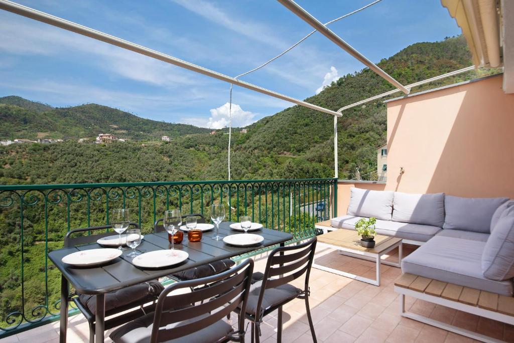 a patio with a table and chairs on a balcony at Casa Luci in Levanto