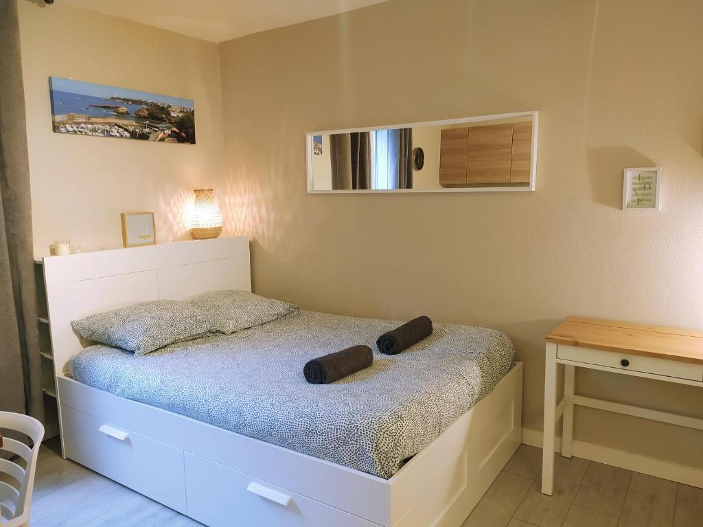 une petite chambre avec un lit et une table dans l'établissement Baiona Sainte Cath 3-HIRU cœur de Saint Esprit, à Bayonne