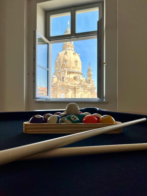 Hotel Luxury Home / 3-Raum-Suite an der Frauenkirche / 6, a pool table with cue balls in front of a window at Luxury Home / 3-Raum-Suite an der Frauenkirche / 6 in Dresden