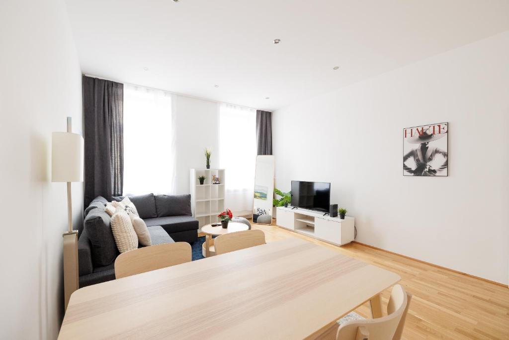 ein Wohnzimmer mit Tisch und Couch in der Unterkunft Charming Apartment near Center in Wien