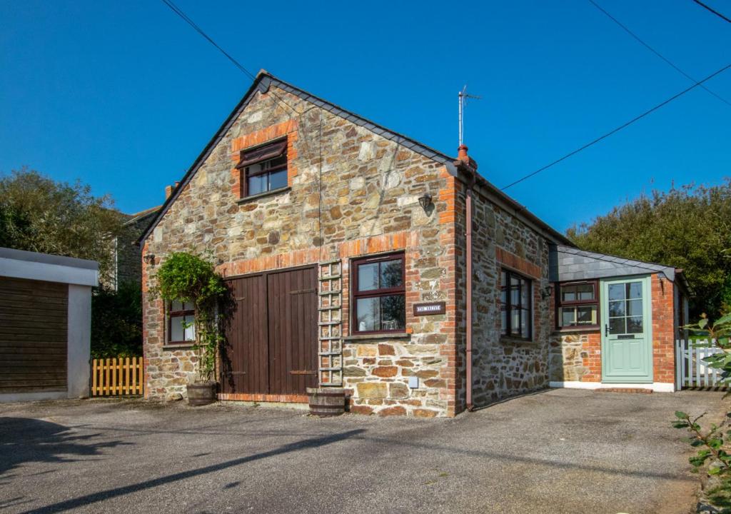 a brick house with a garage in front of it at The Smithy in Gunwalloe