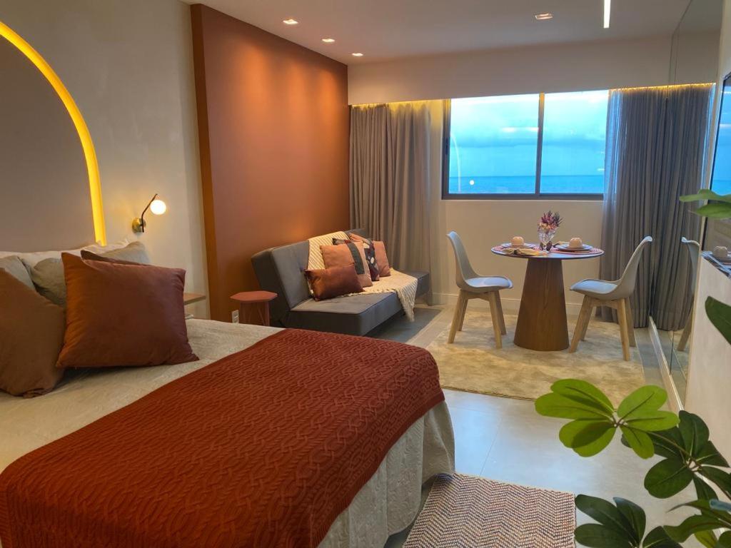 um quarto de hotel com uma cama, uma mesa e cadeiras em Flat Beach Class Executive - Beira Mar de Boa Viagem em Recife