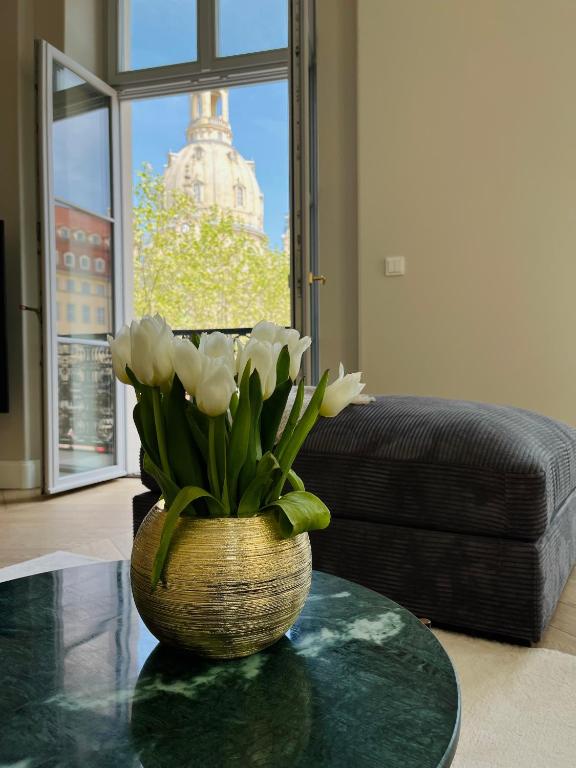 Hotel Luxury Home / 3-Raum-Suite an der Frauenkirche / 2, a vase with white flowers on a table in a living room at Luxury Home / 3-Raum-Suite an der Frauenkirche / 2 in Dresden
