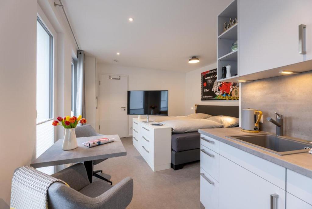 una cocina con fregadero y una cama en una habitación en Haus Andersen Apartment DREI en Norderney