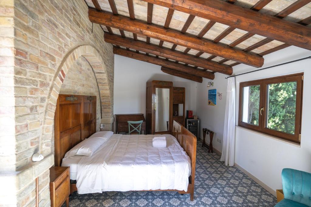 een slaapkamer met een bed en een bakstenen muur bij Dimora Morello in Poggio Morello
