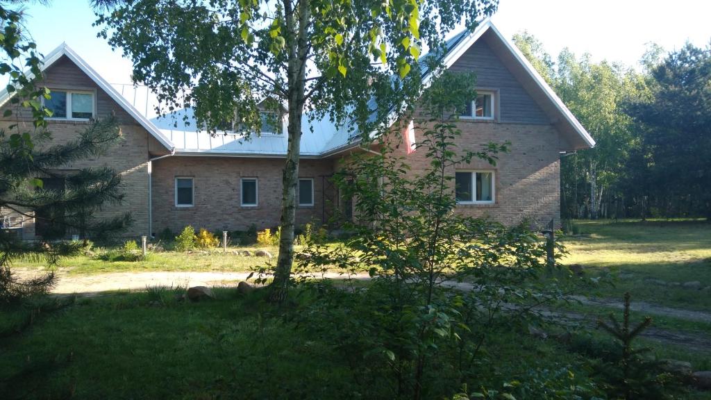 ein Backsteinhaus mit einem Baum davor in der Unterkunft Siedlisko w Dolinie Wieprza 