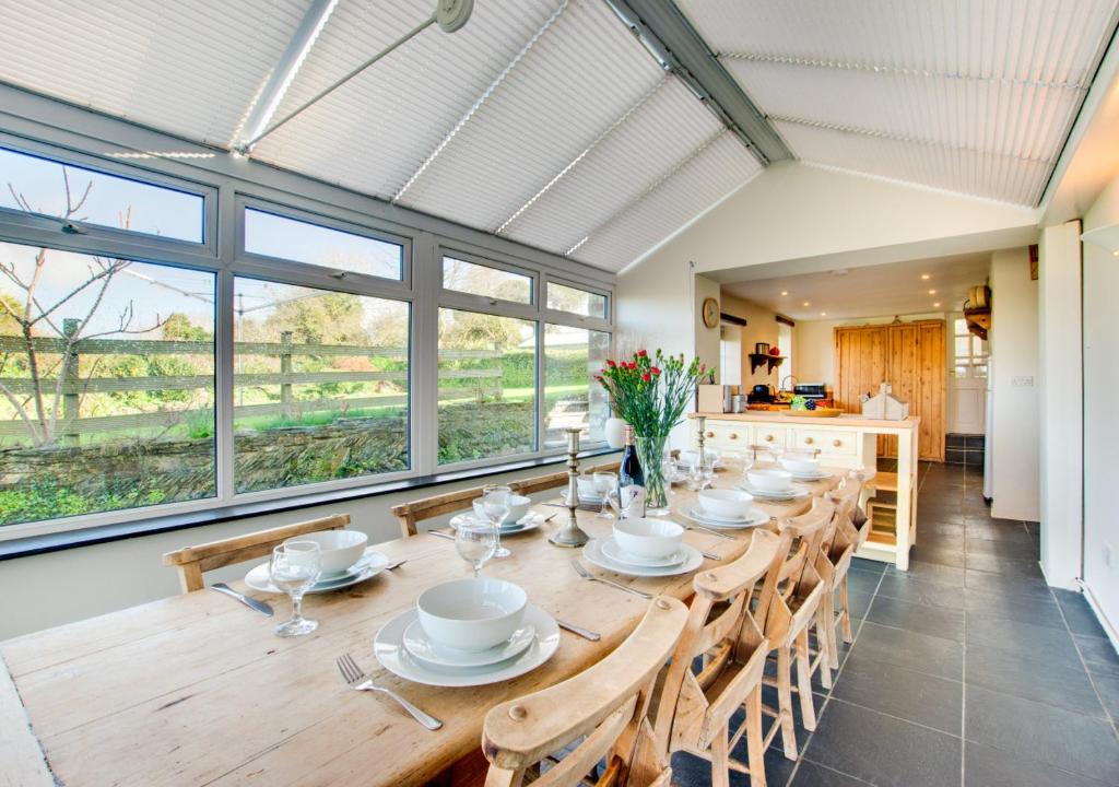 a large dining room with a long table and chairs at Cross House in Saint Issey