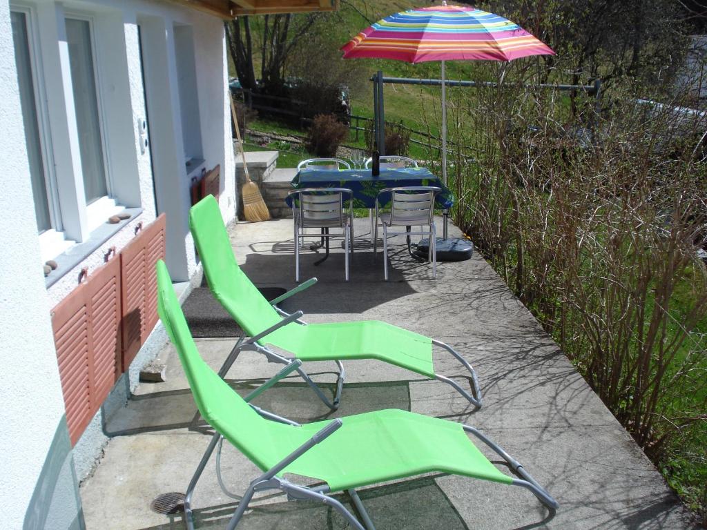 a group of chairs and an umbrella on a patio at Chalet Viola in Wengen