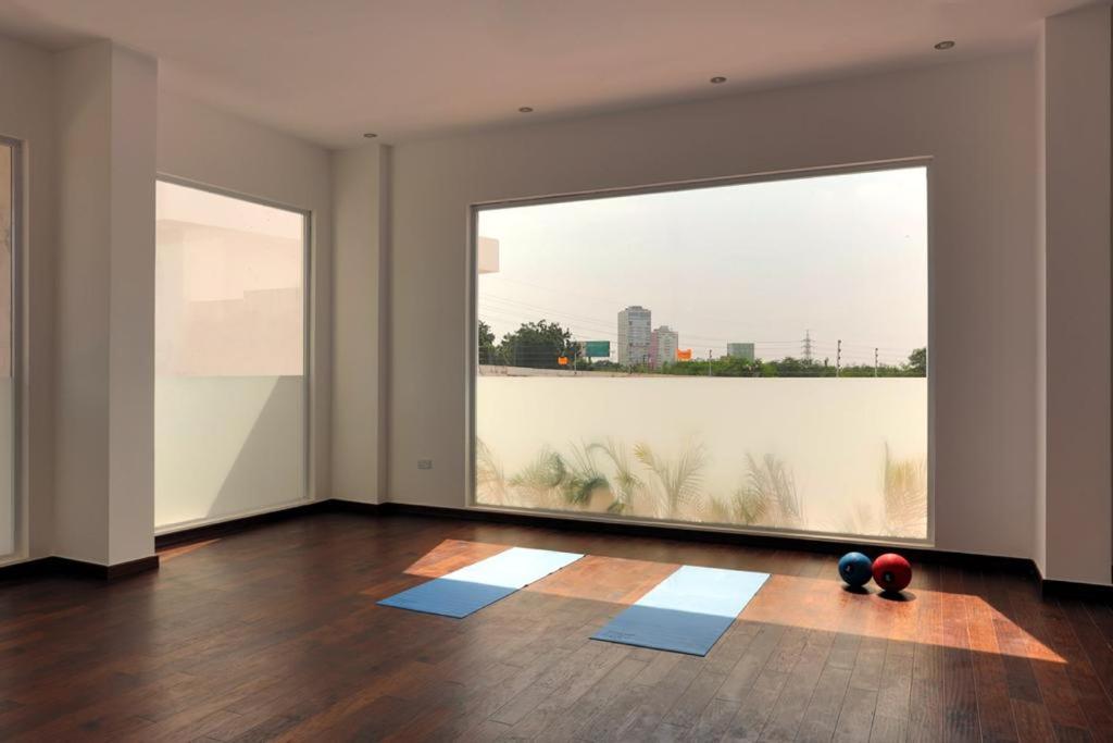 een lege kamer met een groot raam met blauwe matten bij Prinarks luxury Apartment in Accra
