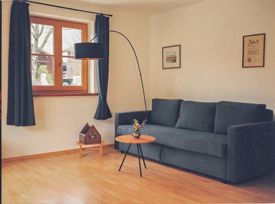 a living room with a blue couch and a table at Apartment im Obstgarten in Rottau