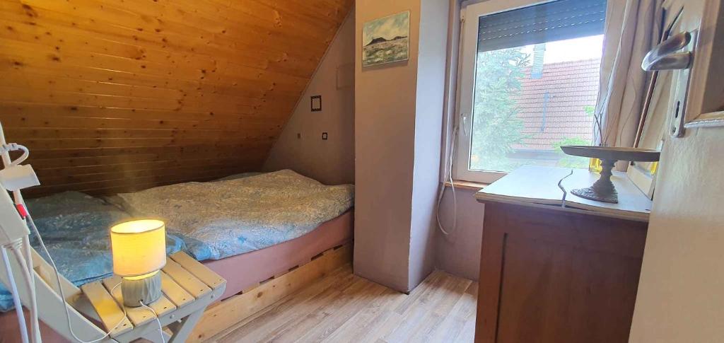 a small bedroom with a bed and a window at Apartment Balatonfenyves/Balaton 26709 in Balatonfenyves