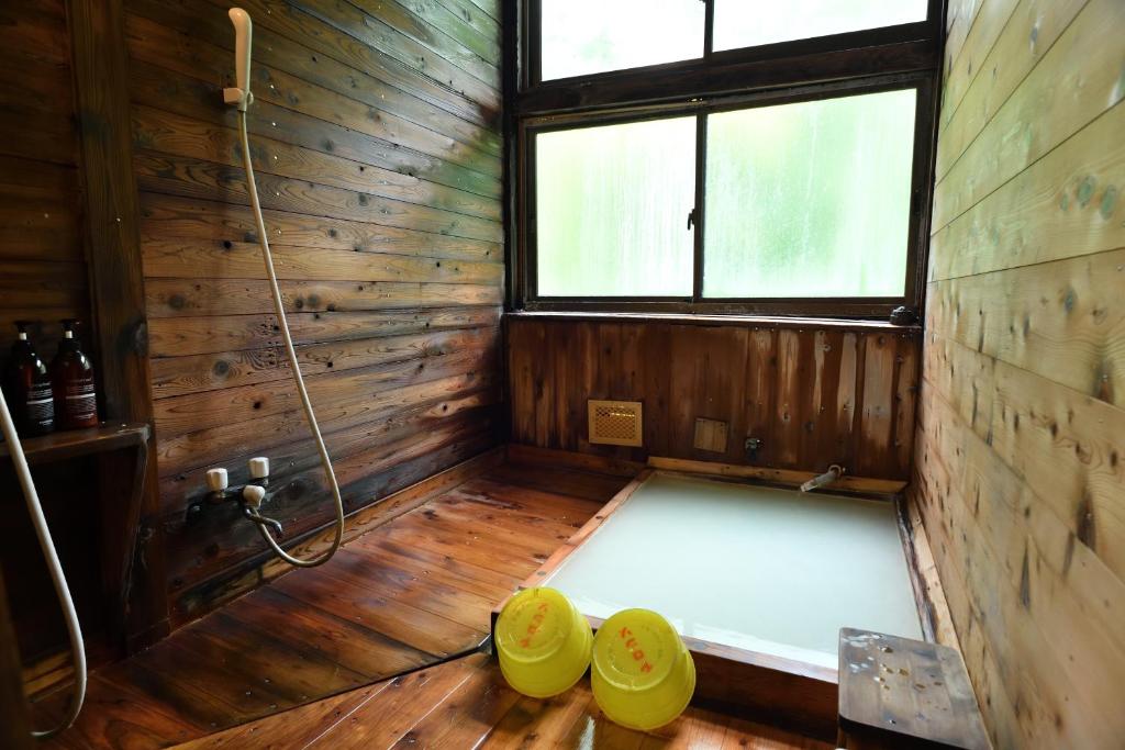 an inside view of a sauna with a tub and windows at Guesthouse Hoshizora no Akari in Matsumoto