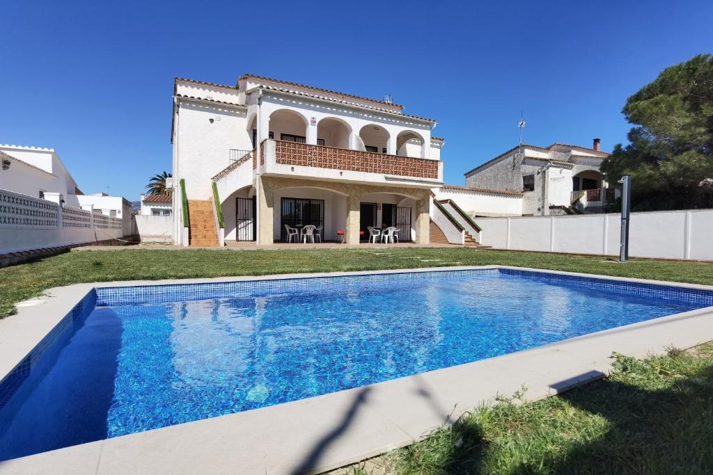 a villa with a swimming pool in front of a house at LEON INMO Apartment Dante - 15774 in Empuriabrava