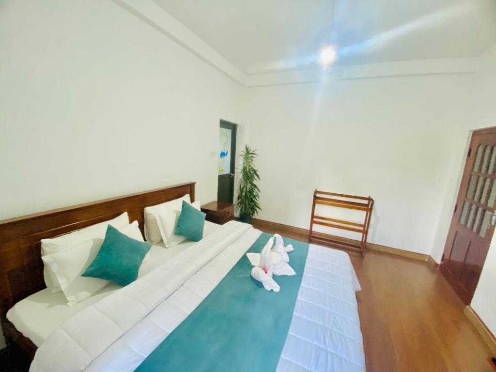 a bedroom with a bed with two stuffed animals on it at Highest Village Bungalow in Nuwara Eliya