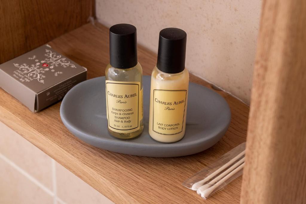 two bottles of essential oils sitting on a shelf at Hôtel de Lion sur Mer in Lion-sur-Mer