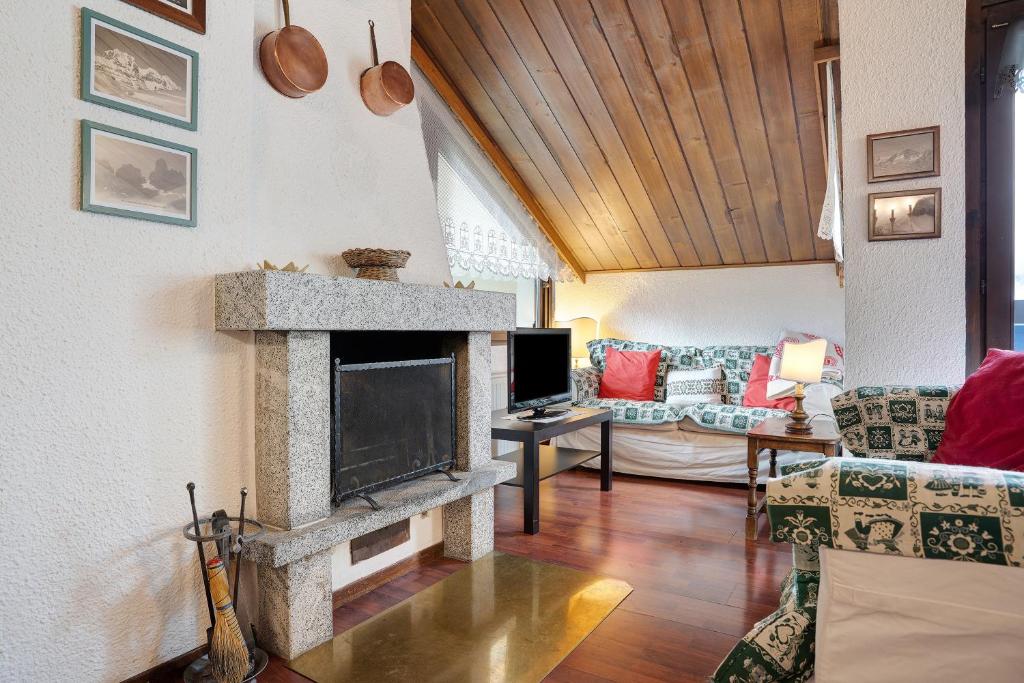 a living room with a fireplace and a couch at Il Cirmolo in Madonna di Campiglio