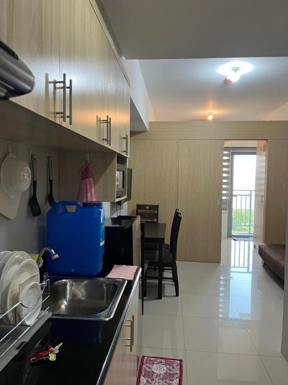 uma cozinha com um lavatório e uma sala de jantar em Grass Fern Residences Tower 5 em Manila
