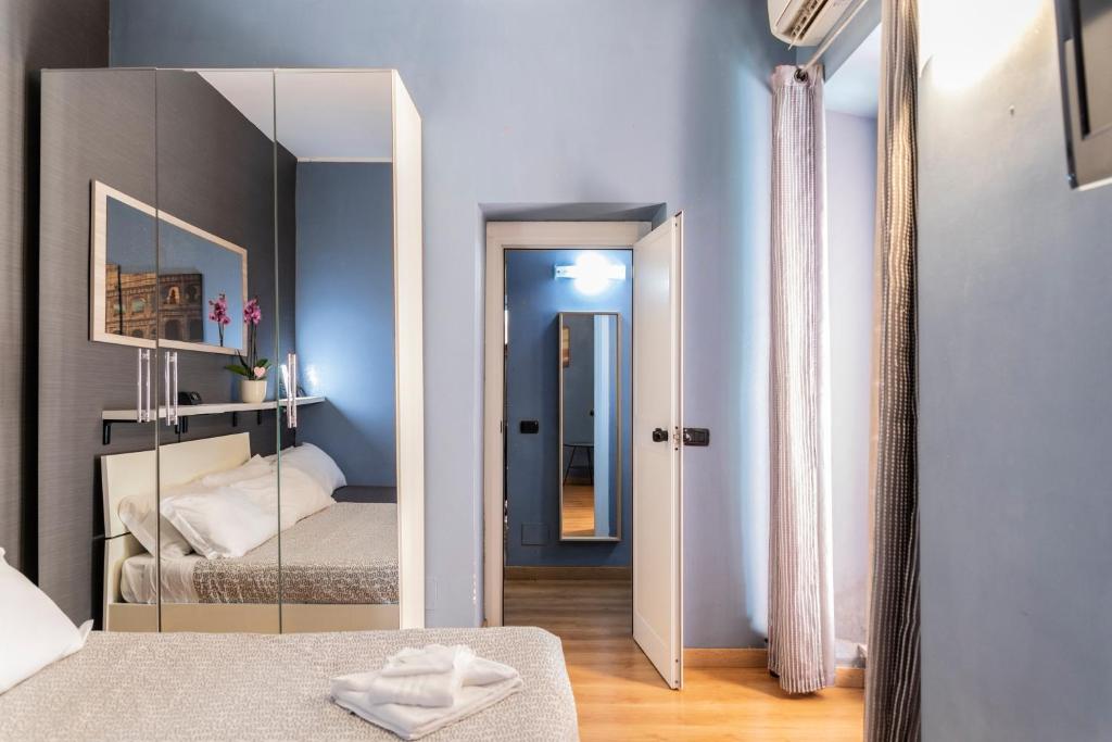 a bedroom with a mirror and a bed in it at Dulcis In Colosseo Apartments in Rome
